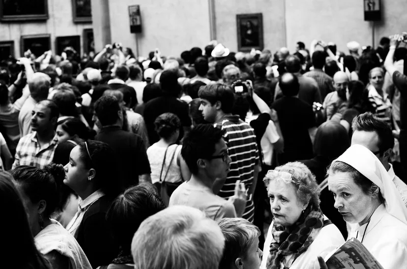 Dense crowd of people packed together, black and white
