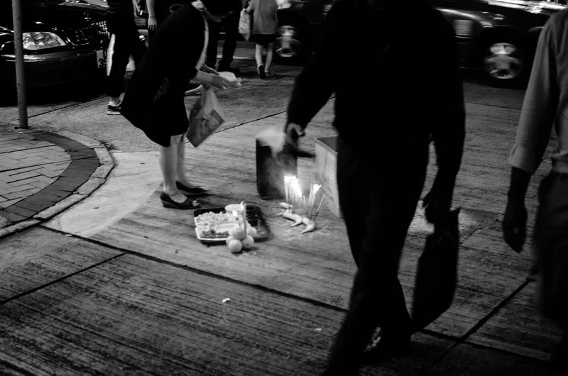 Pedestrians with shopping bags on a pavement, black and white