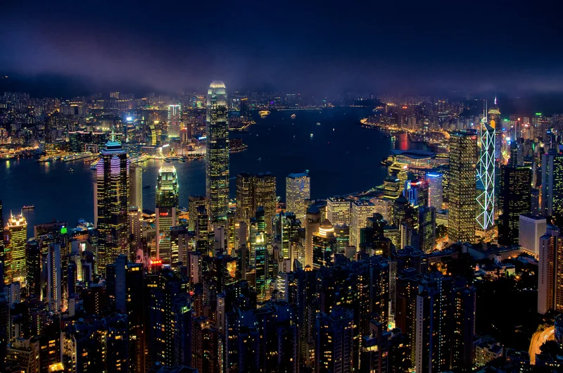 Dense illuminated skyline at night seen from a hilltop