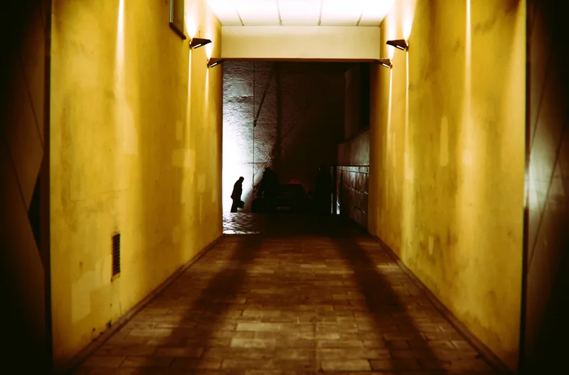Long yellow corridor with a figure at the far end