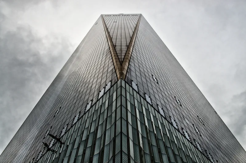 Skyscraper corner rising into cloud, seen from below