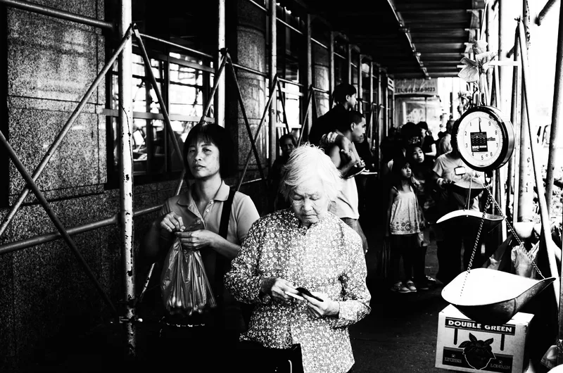 Busy covered market, shoppers browsing, black and white