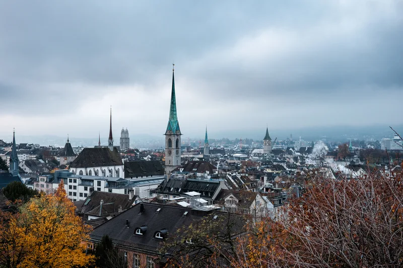 Church spires and rooftops under heavy autumn cloud