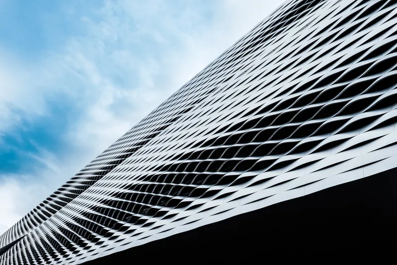 Curved lattice façade of a tower against blue sky