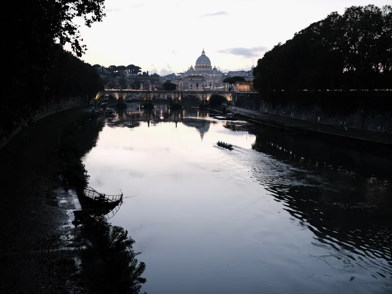 River bend at dusk with a domed basilica beyond