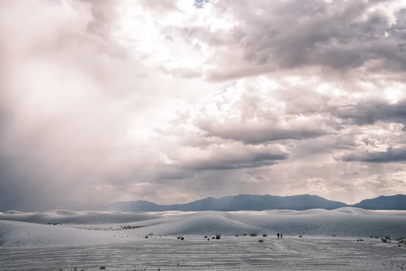 Pale dunes under a wide bank of cloud