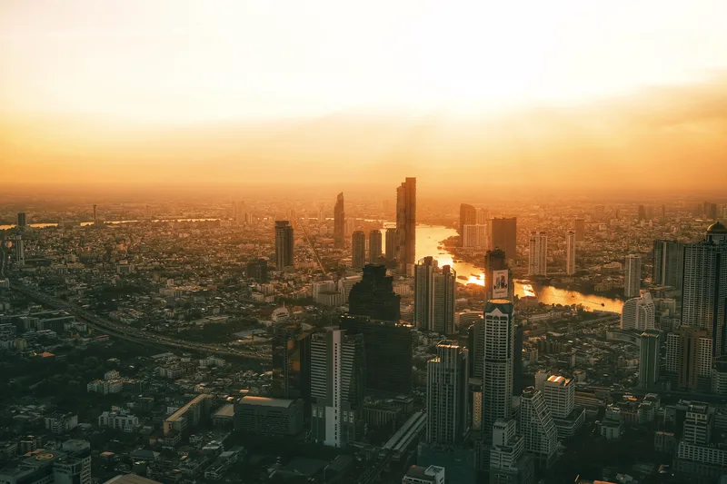 City skyline at sunset from above, a river winding through