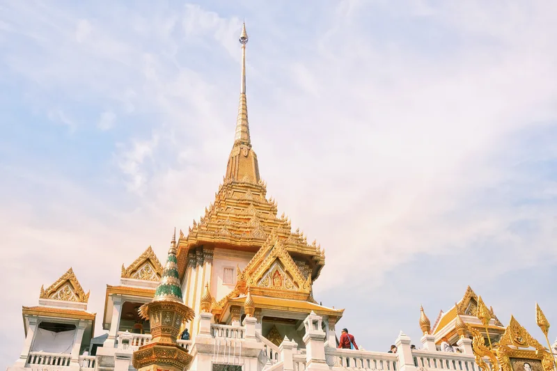 Golden temple spire against a pale blue sky