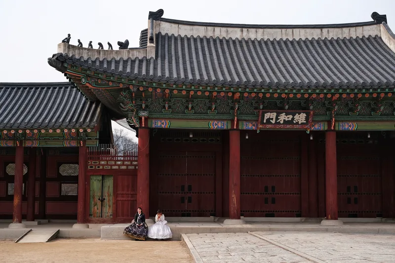 Traditional tiled gate with figures in formal robes