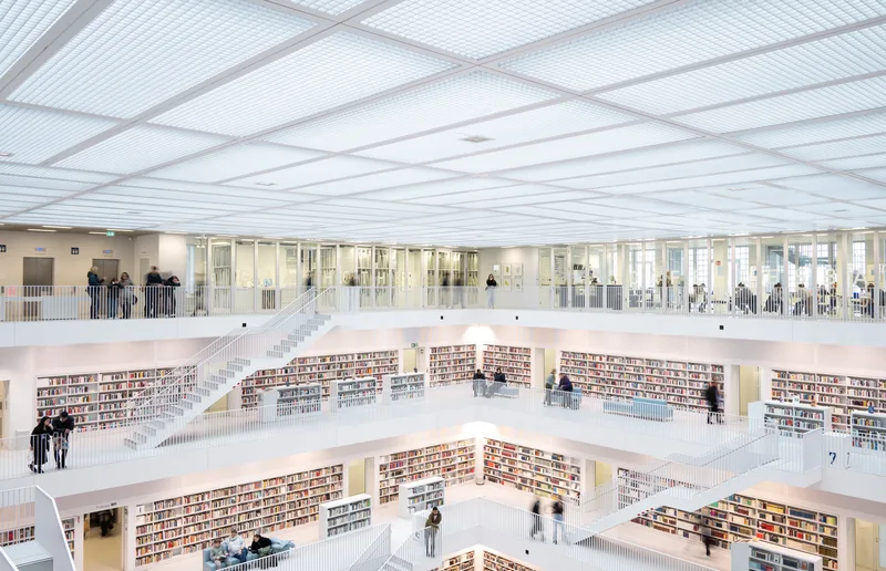 White multi-storey library atrium lined with book-filled balconies