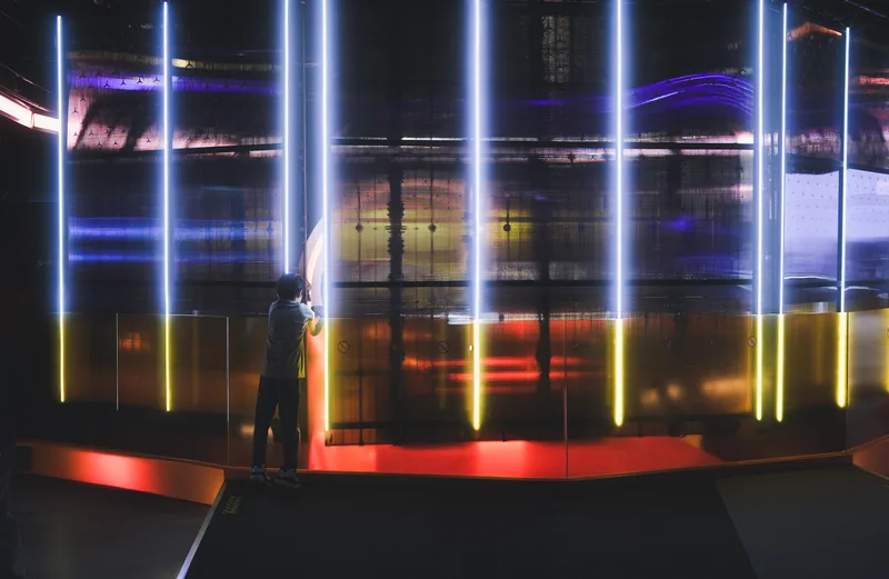 Figure among vertical bars of coloured light