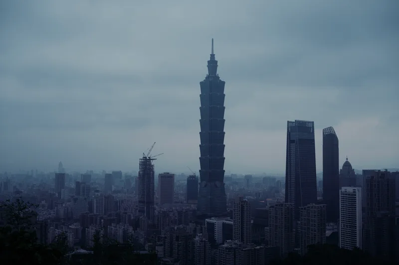 Taipei 101 rising above the city under low grey cloud