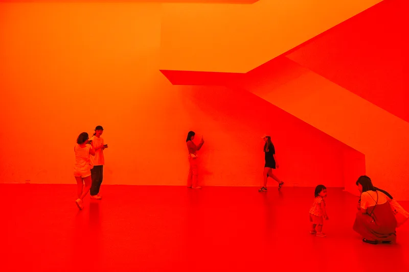 Figures walking through a room saturated in red light