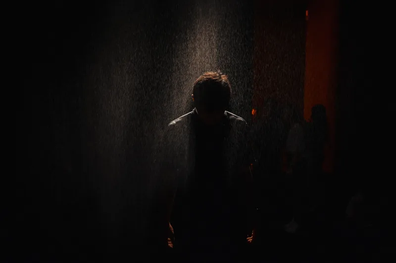 Figure in darkness lit by a faint warm glow