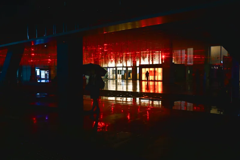Red-lit bar interior glowing behind glass at night