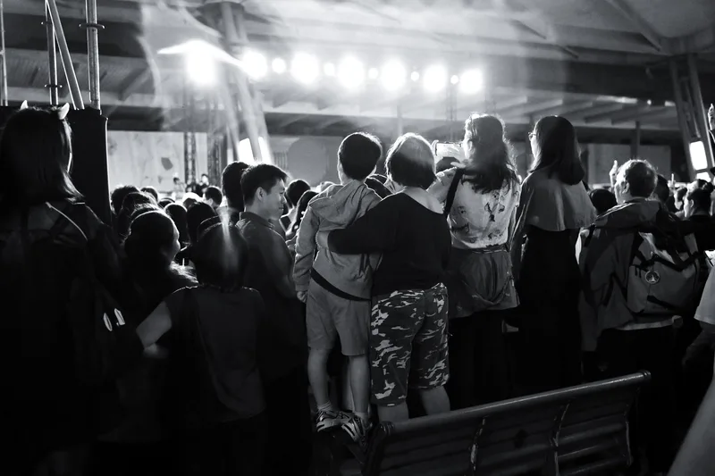 Crowd under a marquee at night, black and white